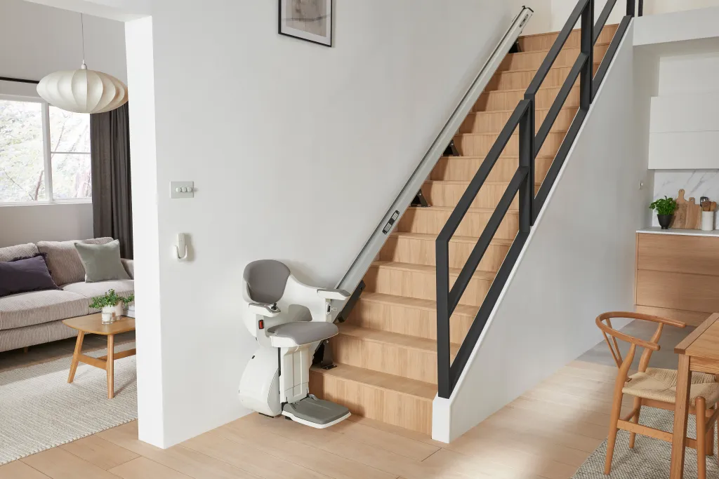 A stairlift installed on a wooden staircase in a home.