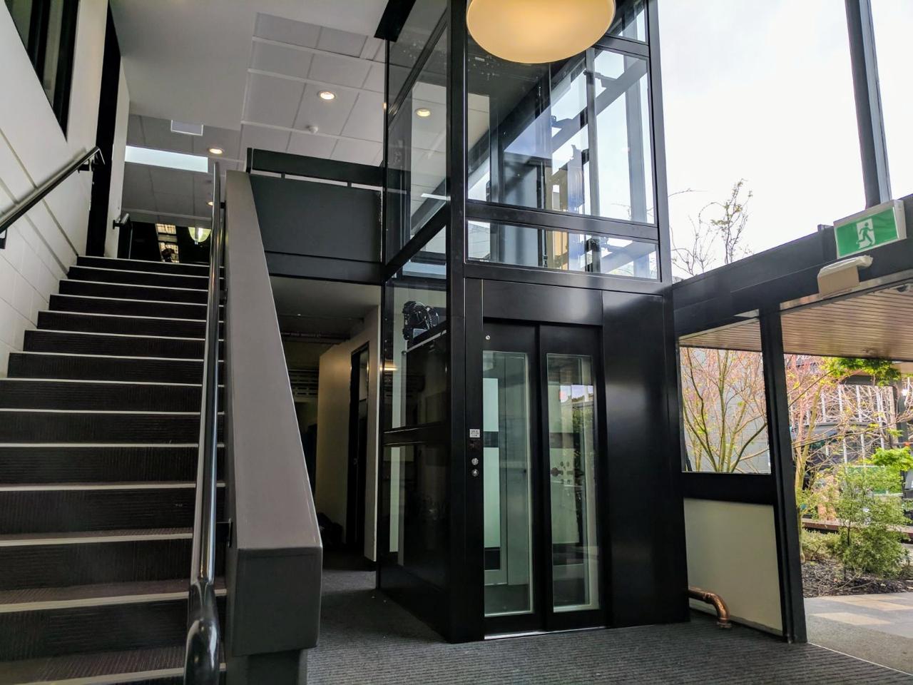 A platform lift with glass walls in a public building.
